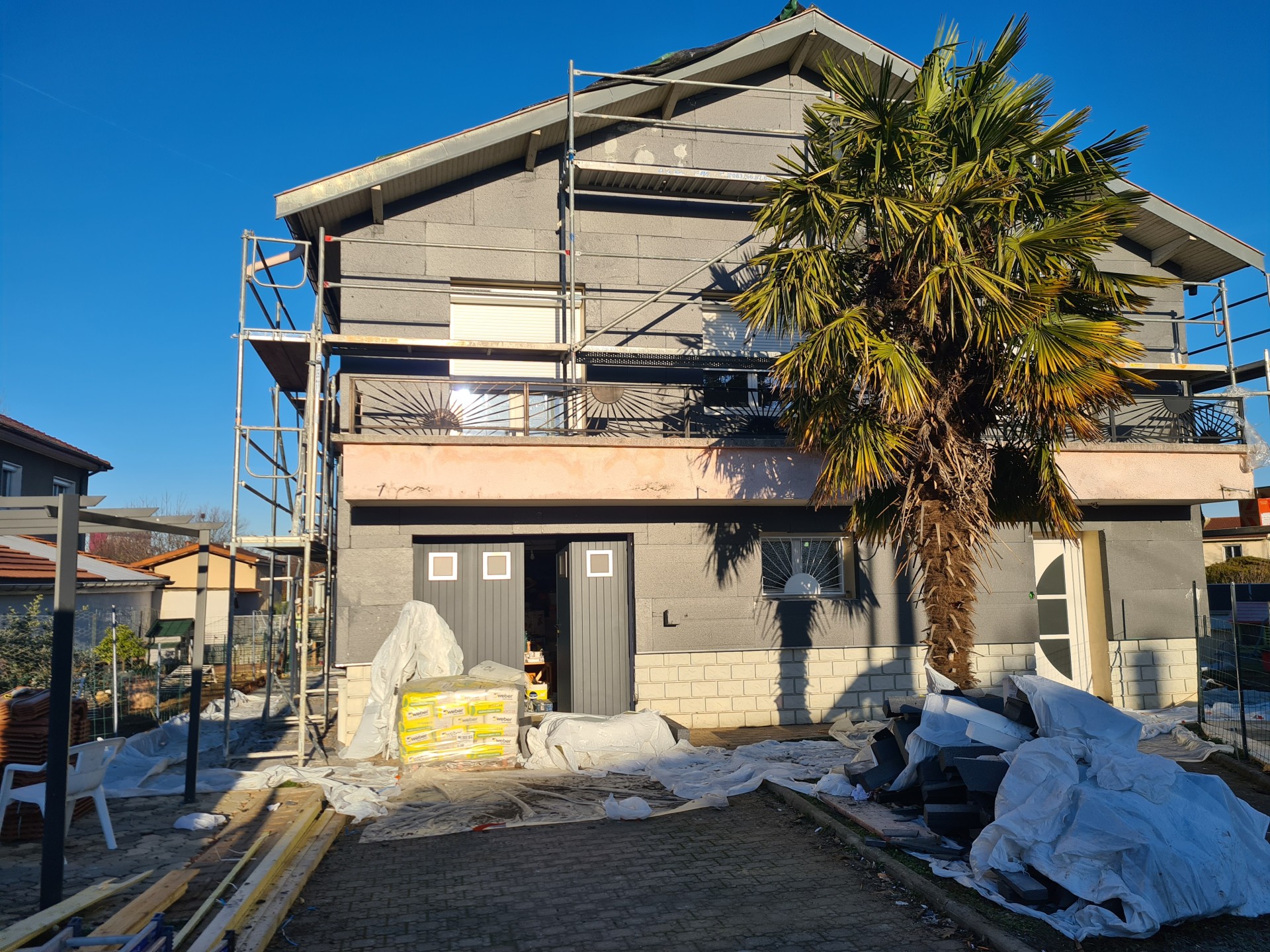 Isolation thermique extérieure ITE façade arrière maison Lyon pose panneaux isolant graphite échafaudage chantier rénovation énergétique entreprise RGE Vaulx-en-Vélin Bron artisan qualifié Qualibat